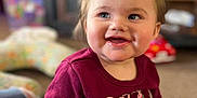 Harper joined the competition — help win amazing prizes! baby, child, smiling, indoor, yellow_bow, maroon_shirt, happy, face, portrait, toddler, hand, sitting, clothing, person, cute, young_child, expression, home, background, soft_focus