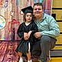 Charlee joined the competition — help win amazing prizes! child, adult, graduation_gown, cap, shoes, floor, wooden_floor, backdrop, drawing, illustration, smile, posing, celebration, indoor, person, curly_hair, jacket, casual_clothing, happy, event