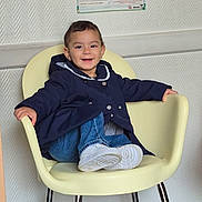 Maya a rejoint le concours — aidez-le/la à gagner de superbes lots ! child, toddler, smiling, waiting_room, chair, jacket, denim, white_shoes, sneakers, poster, wallpaper, indoor, portrait, happy, hair, legs, metal_chair_legs, floor, clinic, seated
