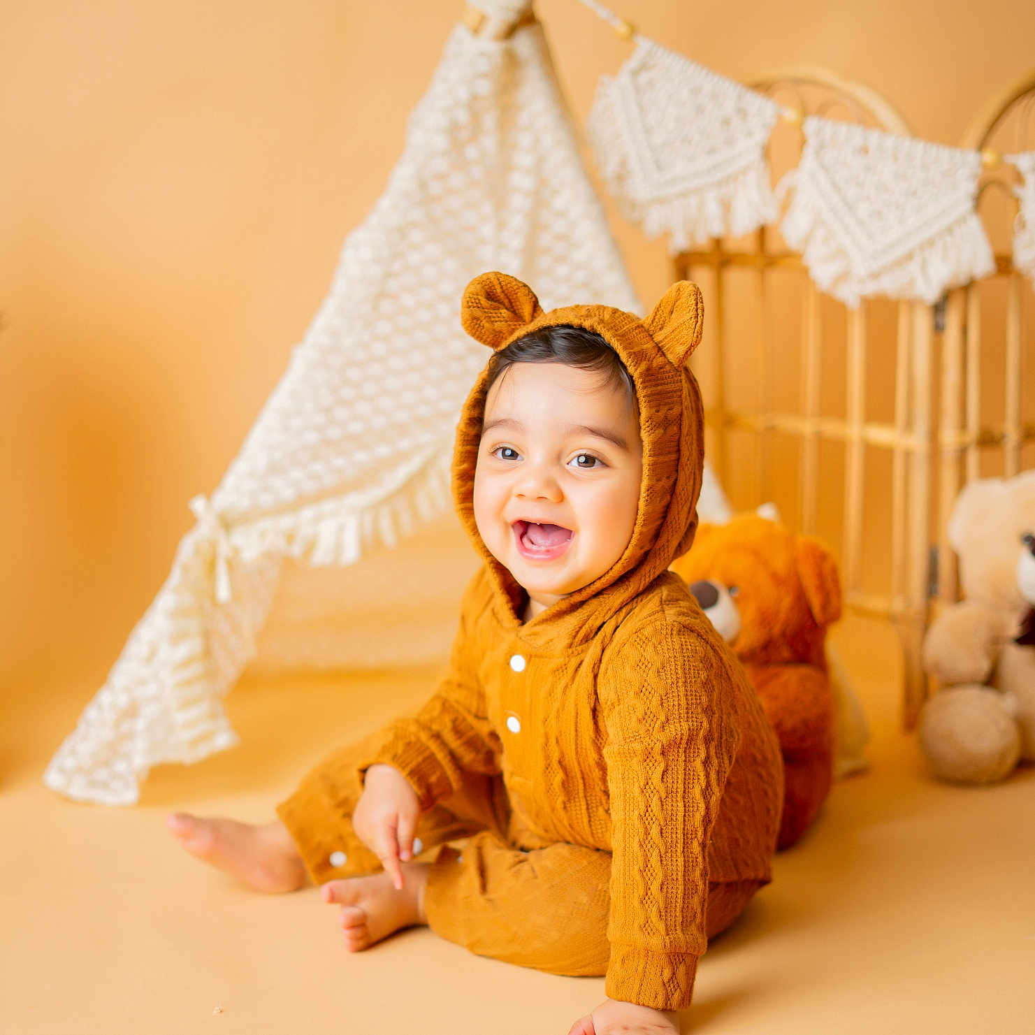 Vyu is registered to the contest to win money with this photo: baby, bear_ears, child, cozy, cute, cute_outfit, decor, floor, happy, indoor, infant, knitted_clothing, portrait, sitting, smiling, soft_lighting, teddy_bear, teepee, toys, warm_colors