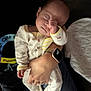 adult_hand, baby, caring, closeup, comfort, cozy, cute, face, fist, holding, indoor, infant, pajamas, peaceful, person, rest, sleeping, soft_lighting, tender, wristwatch