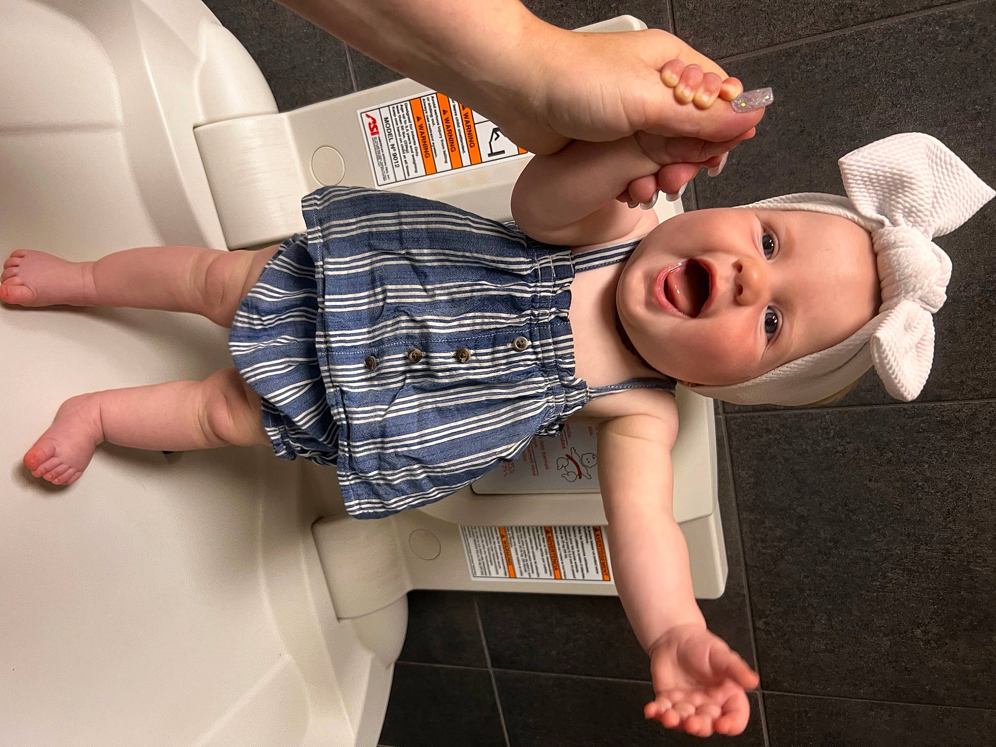 Saydie is registered to the contest to win money with this photo: baby, baby_toddler_clothing, comfort, elbow, eyewear, finger, foot, gesture, happy, hat, human_leg, joint, knee, person, sleeve, smile, sun_hat, textile, thigh, toddler