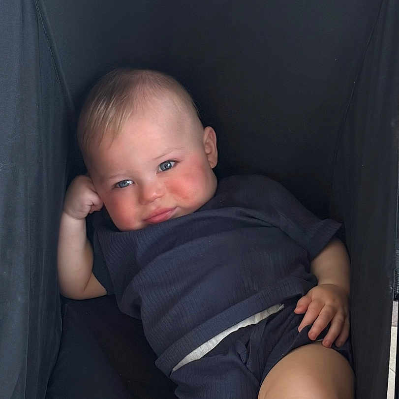 Rouxè is registered to the contest to win money with this photo: baby, bed, clothing, cradle, crib, cushion, face, furniture, happy, head, homedecor, infantbed, newborn, person, photography, portrait, shorts, sleeping, smile, stroller