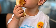 Tiago a rejoint le concours — aidez-le/la à gagner de superbes lots ! child, toddler, boy, eating, toast, food, shirt, baby_shark, smiling, cute, indoors, short_hair, hand, face, person, clothing, sitting, bright, colorful, happy