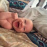Layton joined the competition — help win amazing prizes! baby, smiling, infant, blanket, bedspread, pattern, happy, cute, lying_down, fist, skin, child, indoors, cozy, comfort, expression, person, mouth_open, head, cheerful