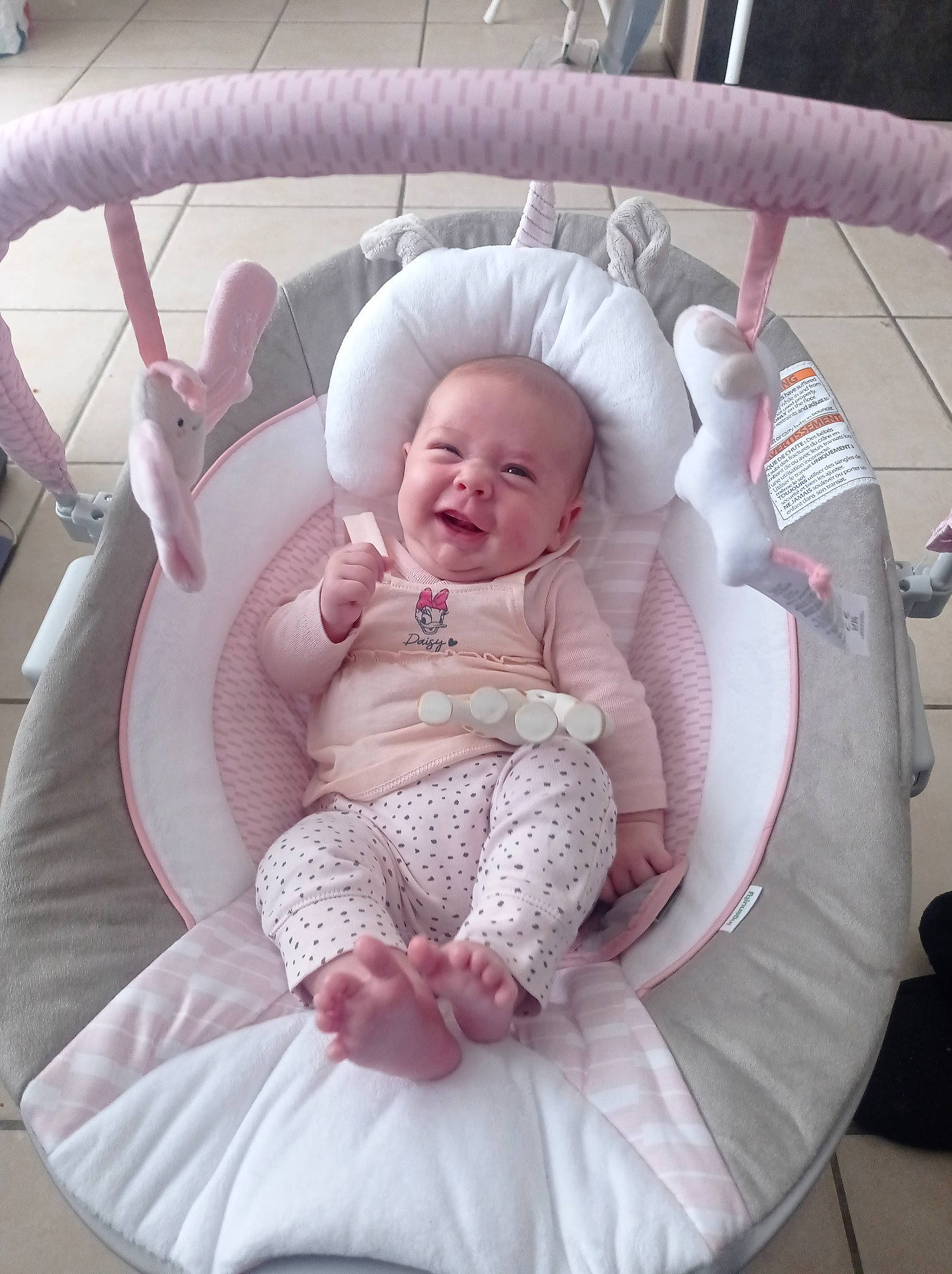 Norah participe au concours pour gagner de l'argent avec cette photo : baby, baby_carriage, baby_products, baby_toddler_clothing, car_seat, chair, child, comfort, head, lap, magenta, pattern, person, pink, product, purple, room, sitting, smile, textile