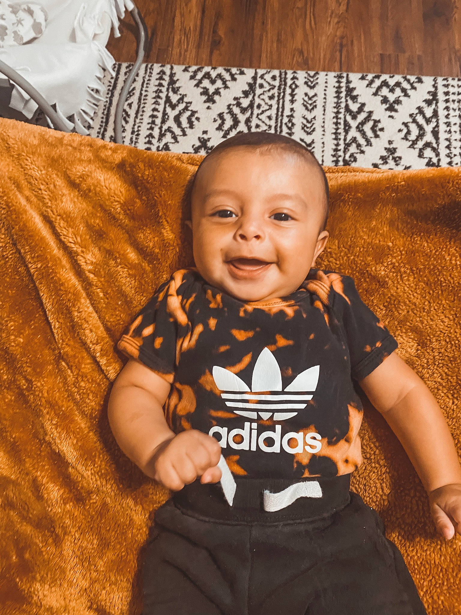 Lux is registered to the contest to win money with this photo: arm, baby, baby_toddler_clothing, brown, clothing, eye, face, flash_photography, floor, flooring, hairstyle, happy, head, person, skin, sleeve, smile, t_shirt, toddler, white