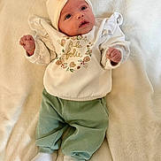Lizéa participe au concours pour gagner de l'argent avec cette photo : baby, bed, blanket, clothing, cozy, cute, eyes, face, floral_print, green_pants, hands, hat, headband, infant, lying_down, newborn, portrait, socks, soft_texture, white_top