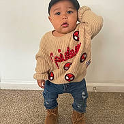 Zion is registered to the contest to win money with this photo: toddler, child, baby, portrait, standing, indoors, sweater, cap, jeans, boots, fashion, cute, serious_expression, hand_on_head, carpet, wall, clothing, full_body, photography, spiderman