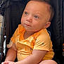 baby, child, stroller, yellow_shirt, cute, infant, sitting, hands, expression, face, eyes, clothing, comfort, portrait, casual, indoors, soft_light, closeup, young, adorable