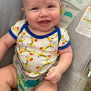 Connor joined the competition — help win amazing prizes! baby, child, smile, onesie, giraffe_pattern, baby_seat, infant, cute, happy, sitting, clothing, face, arm, hand, furniture, indoor, colorful, pattern, skin, portrait