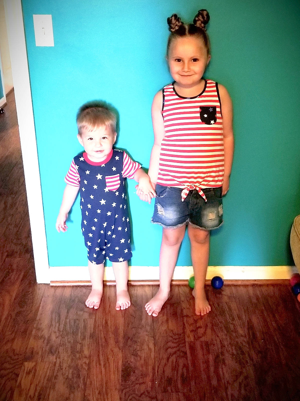 Ameilia is registered to the contest to win money with this photo: baby_toddler_clothing, child, daughter, design, floor, flooring, fun, gesture, happy, joy, pattern, person, play, shoe, shoulder, sibling, sitting, skin, smile, standing