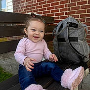 Shylah joined the competition — help win amazing prizes! backpack, bench, blue_jeans, brick_wall, casual_clothing, child, concrete, cute, daylight, grass, hair_clips, happy, outdoor, person, pink_boots, pink_sweater, playful, sitting, smiling, toddler