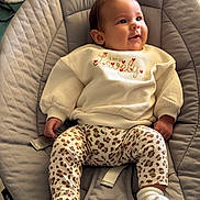 Emma a rejoint le concours — aidez-le/la à gagner de superbes lots ! baby, infant, sitting, quilted_seat, gray, cream_sweater, leopard_print_pants, socks, face, happy_expression, indoor, clothing, child, cute, portrait, cozy, soft_lighting, fabric, seat, hands