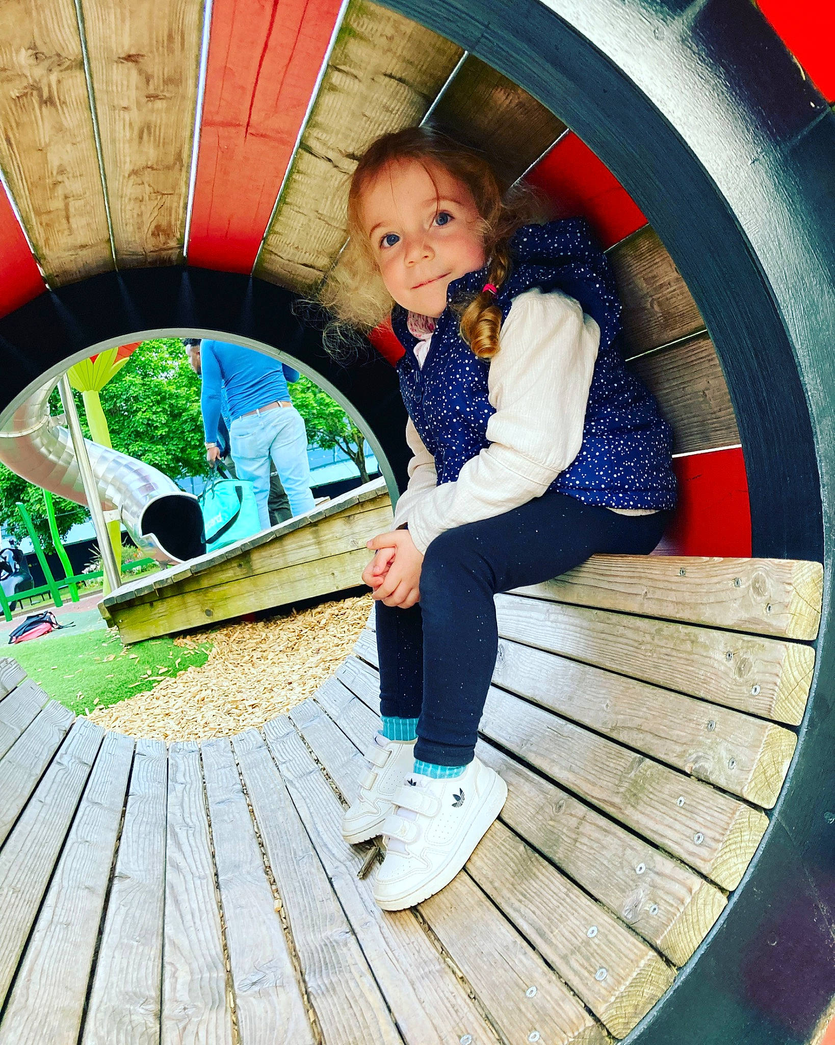 Lara participe au concours pour gagner de l'argent avec cette photo : automotive_tire, child, circle, electric_blue, fun, grass, green, jacket, leisure, line, person, photograph, plant, recreation, sitting, stairs, tire, toddler, tree, wheel