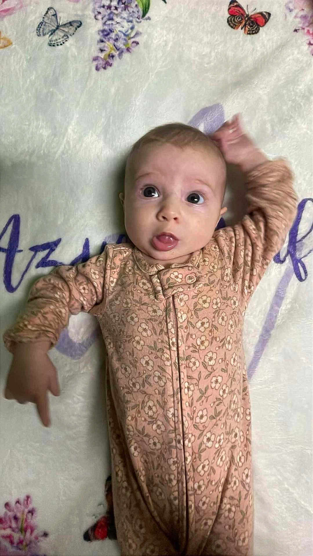 Azrael joined the competition — help win amazing prizes! baby, infant, onesie, floral_pattern, blanket, butterfly, flower, lying_down, curious, wide_eyes, soft_texture, hand_up, child, young, cute, indoors, portrait, sleepwear, comfortable, expression