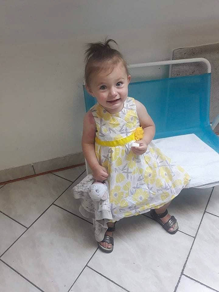 Camelia a rejoint le concours — aidez-le/la à gagner de superbes lots ! baby, child, dress, floor, flooring, joy, person, play, product, sitting, skin, smile, toddler, vacation, yellow