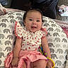 Gracelynn is registered to the contest to win money with this photo: baby, child, infant, smiling, pigtails, clothing, pink, white, elephant_pattern, pillow, toy, sitting, indoors, happy, cute, sock, floor, remote_control, shoe, person