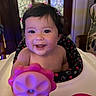 baby, child, smiling, toy, high_chair, indoor, hair_clips, polka_dots, face, happy, person, furniture, table, pink, seat, cute, infant, portrait, home, expression