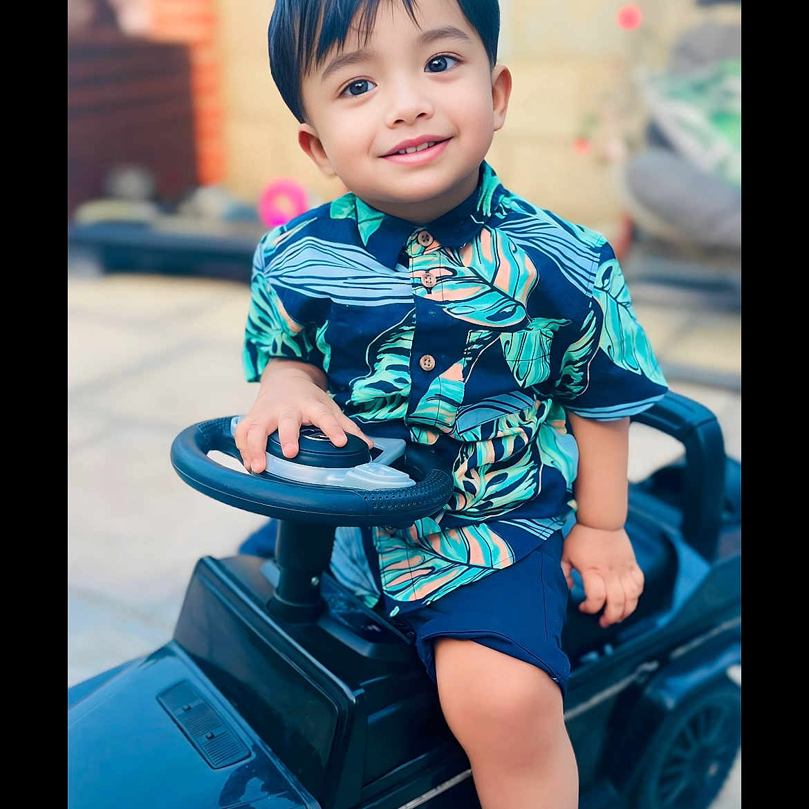 Rafsan is registered to the contest to win money with this photo: blackhair, boy, child, clothing, dress, face, hair, happy, head, machine, male, person, photography, portrait, shorts, sitting, sleeve, smile, transportation, vehicle