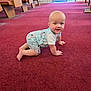 Colton joined the competition — help win amazing prizes! baby, crawling, carpet, indoor, child, blue_outfit, koala_print, wooden_bench, red_carpet, natural_light, smiling, playful, floor, window, door, person, infant, cute, young_child, happy
