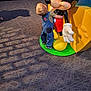 Gabriel joined the competition — help win amazing prizes! toddler, child, denim_overalls, mickey_mouse, statue, indoor, carpet, shoes, toy, hugging, yellow, green, blue, playful, shadow, floor, person, back_view, cute, casual_clothing