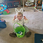 Gabriel joined the competition — help win amazing prizes! toddler, bunny_ears, easter_basket, carpet, toy, indoor, child, smiling, bow_tie, shoes, suspenders, television, cabinet, baby_swing, plastic_eggs, person, home, furniture, play_area, happy