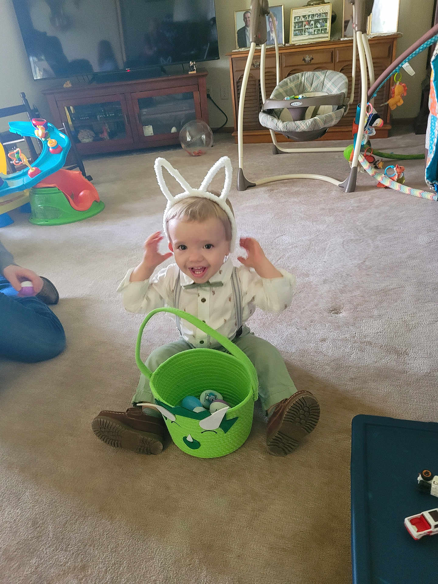 Gabriel joined the competition — help win amazing prizes! toddler, bunny_ears, easter_basket, carpet, toy, indoor, child, smiling, bow_tie, shoes, suspenders, television, cabinet, baby_swing, plastic_eggs, person, home, furniture, play_area, happy