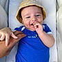 Tommie participe au concours pour gagner de l'argent avec cette photo : baby, child, smiling, blue_onesie, yellow_hat, hand, adult_hand, pacifier, cushion, happy, infant, cute, portrait, skin, fingers, relaxed, comfort, indoor, person, clothing
