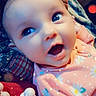 baby, child, infant, smiling, surprised, portrait, close_up, face, eyes, open_mouth, pink_outfit, floral_pattern, blanket, pacifier, toy, indoor, cozy, sparkles, digital_filter, happy