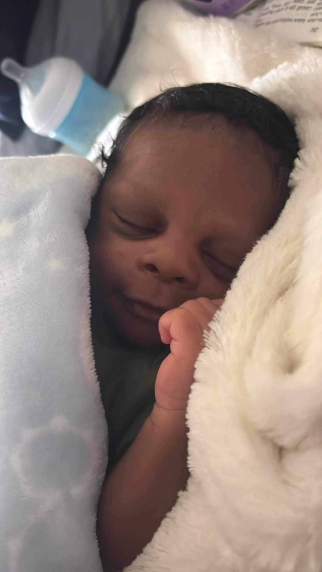 Alijah is registered to the contest to win money with this photo: baby, newborn, sleeping, blanket, soft, infant, peaceful, resting, hand, face, wrapped, cozy, indoors, closeup, bottle, nursery, child, portrait, cuddle, warm