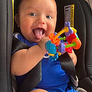 Krisniel joined the competition — help win amazing prizes! baby, blue_clothing, car_seat, cheerful, child, close_up, colorful, cute, fun, happy, holding, indoor, infant, person, playful, seat, seatbelt, smiling, tongue_out, toy