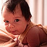 baby, blanket, child, closeup, curious, cute, expression, eyes, face, hair, indoors, infant, knitted_clothing, lying_down, newborn, portrait, skin, soft_texture, toddler, warm_colors