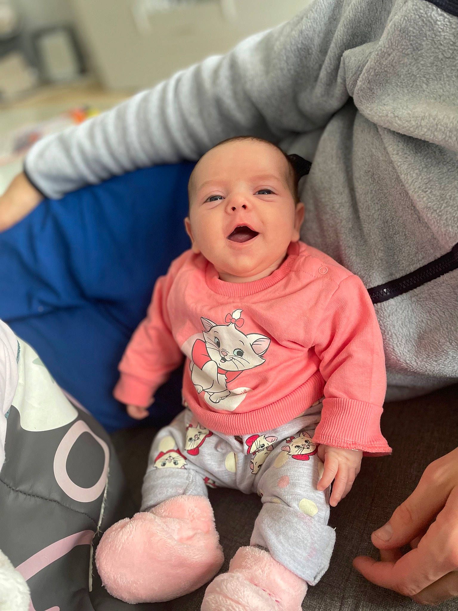 Kamila participe au concours pour gagner de l'argent avec cette photo : baby, baby_toddler_clothing, cheek, child, comfort, finger, flooring, fun, happy, human_leg, knee, linens, mouth, person, sitting, skin, sleeve, smile, t_shirt, thigh