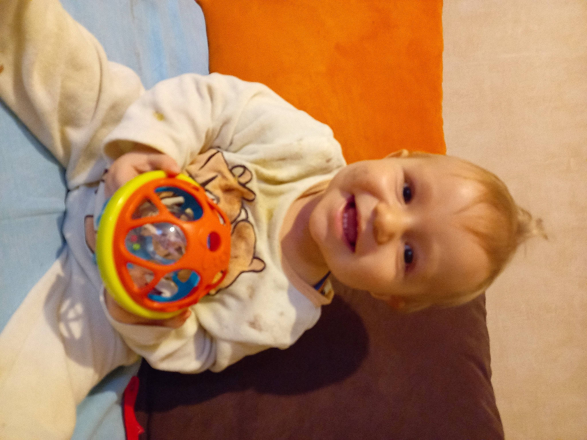 Milan participe au concours pour gagner de l'argent avec cette photo : arm, baby, baby_laughing, baby_toddler_clothing, cheek, child, comfort, fun, happy, joy, mammal, mouth, nose, orange, person, room, skin, sleeve, smile, textile
