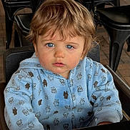Ashton is registered to the contest to win money with this photo: child, toddler, blue_eyes, light_brown_hair, hoodie, bear_pattern, high_chair, indoor, curious_expression, face, seated, clothing, person, furniture, metal_chair, brick_floor, portrait, casual, young_child, cute
