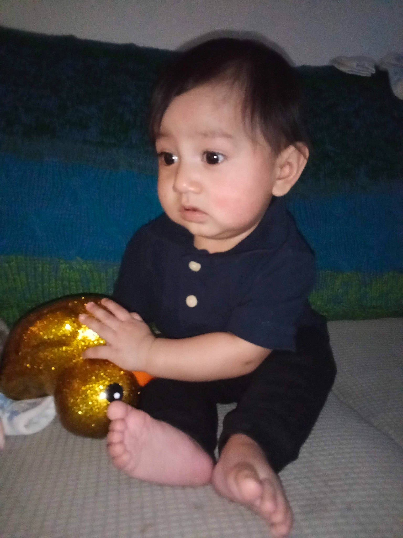 Jeremiah is registered to the contest to win money with this photo: baby, baby_toddler_clothing, cheek, child, finger, flooring, fun, hand, happy, human_leg, nail, nose, person, sitting, sleeve, stuffed_toy, thumb, toddler, toy