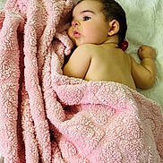 Francesca is registered to the contest to win money with this photo: baby, blanket, pink_blanket, infant, face, earring, skin, lying_down, soft_texture, white_background, child, cute, sleepy, cozy, portrait, young_child, indoors, resting, toddler, wrapped