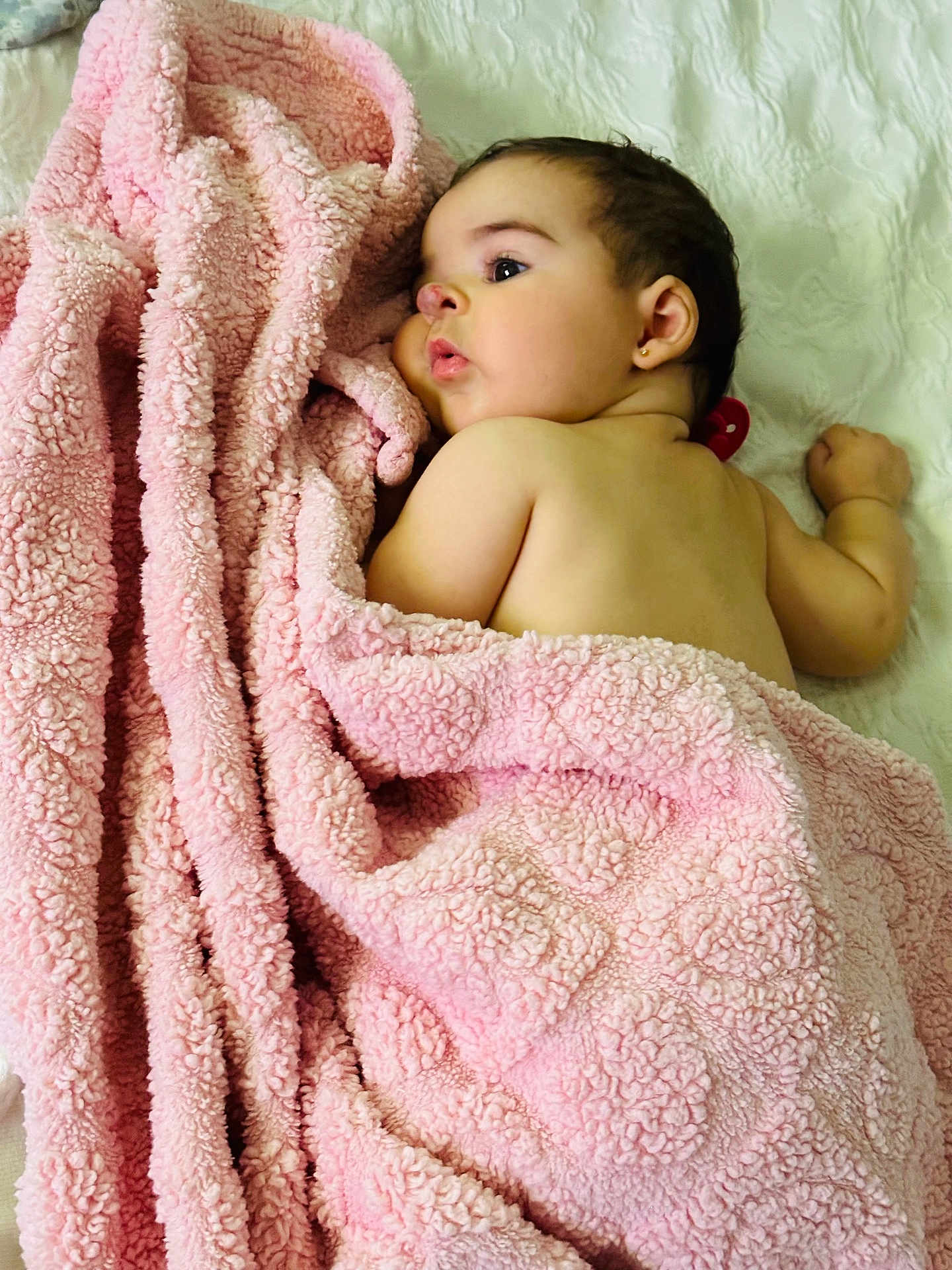Francesca is registered to the contest to win money with this photo: baby, blanket, pink_blanket, infant, face, earring, skin, lying_down, soft_texture, white_background, child, cute, sleepy, cozy, portrait, young_child, indoors, resting, toddler, wrapped