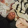 Dhoryian is registered to the contest to win money with this photo: baby, infant, blanket, pillow, face, tongue, expression, sleepwear, mittens, couch, soft, cozy, indoor, child, person, cute, home, resting, floral, comfort