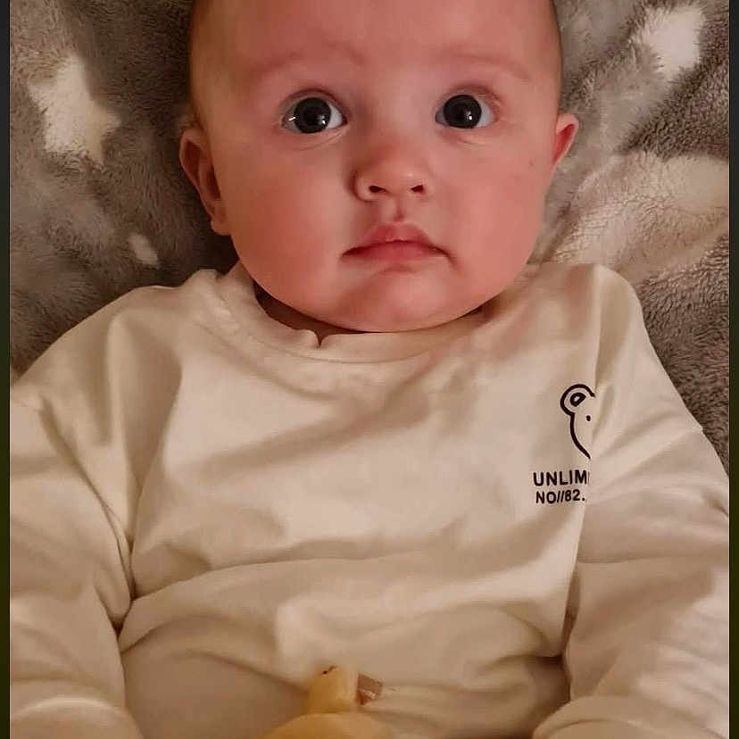 Luca is registered to the contest to win money with this photo: baby, bed, blanket, bodypart, clothing, couch, crib, cushion, face, finger, furniture, hand, hat, head, homedecor, newborn, person, photography, portrait, toy