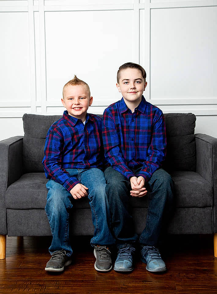 Stetson is registered to the contest to win money with this photo: child, design, family, joy, pattern, people, person, photography, plaid, sibling, sitting, standing, tartan