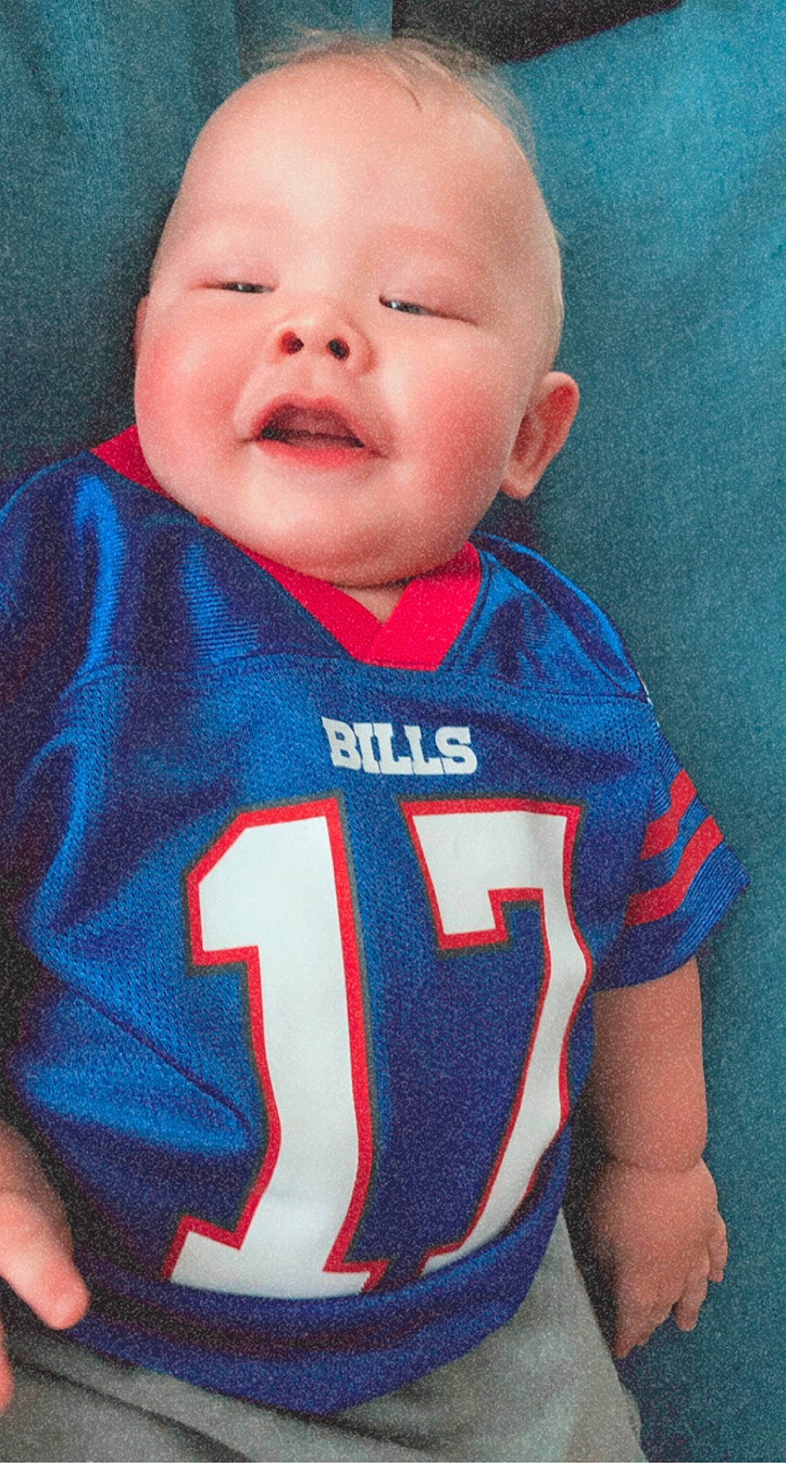 Cash is registered to the contest to win money with this photo: baby_toddler_clothing, cheek, chin, eye, eyebrow, face, hairstyle, happy, head, human_body, iris, jersey, mouth, neck, nose, person, sleeve, smile, sports_jersey, t_shirt