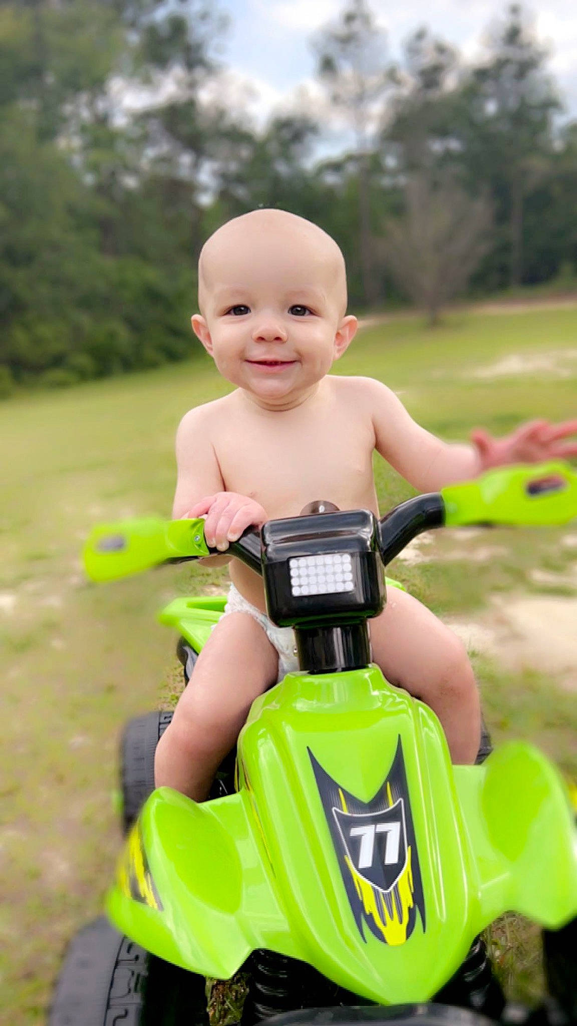 John Henry is registered to the contest to win money with this photo: baby_products, baby_toddler_clothing, bicycle, bicycle_handlebar, fun, grass, happy, head, joy, leisure, people_in_nature, person, personal_protective_equipment, recreation, shorts, smile, tire, toddler, tree, vehicle