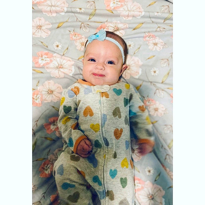 Baylee joined the competition — help win amazing prizes! baby, baby_products, baby_toddler_clothing, baby_toys, child, dress, font, happy, head, headwear, linens, pattern, peach, person, pink, room, sitting, sleeve, smile, t_shirt