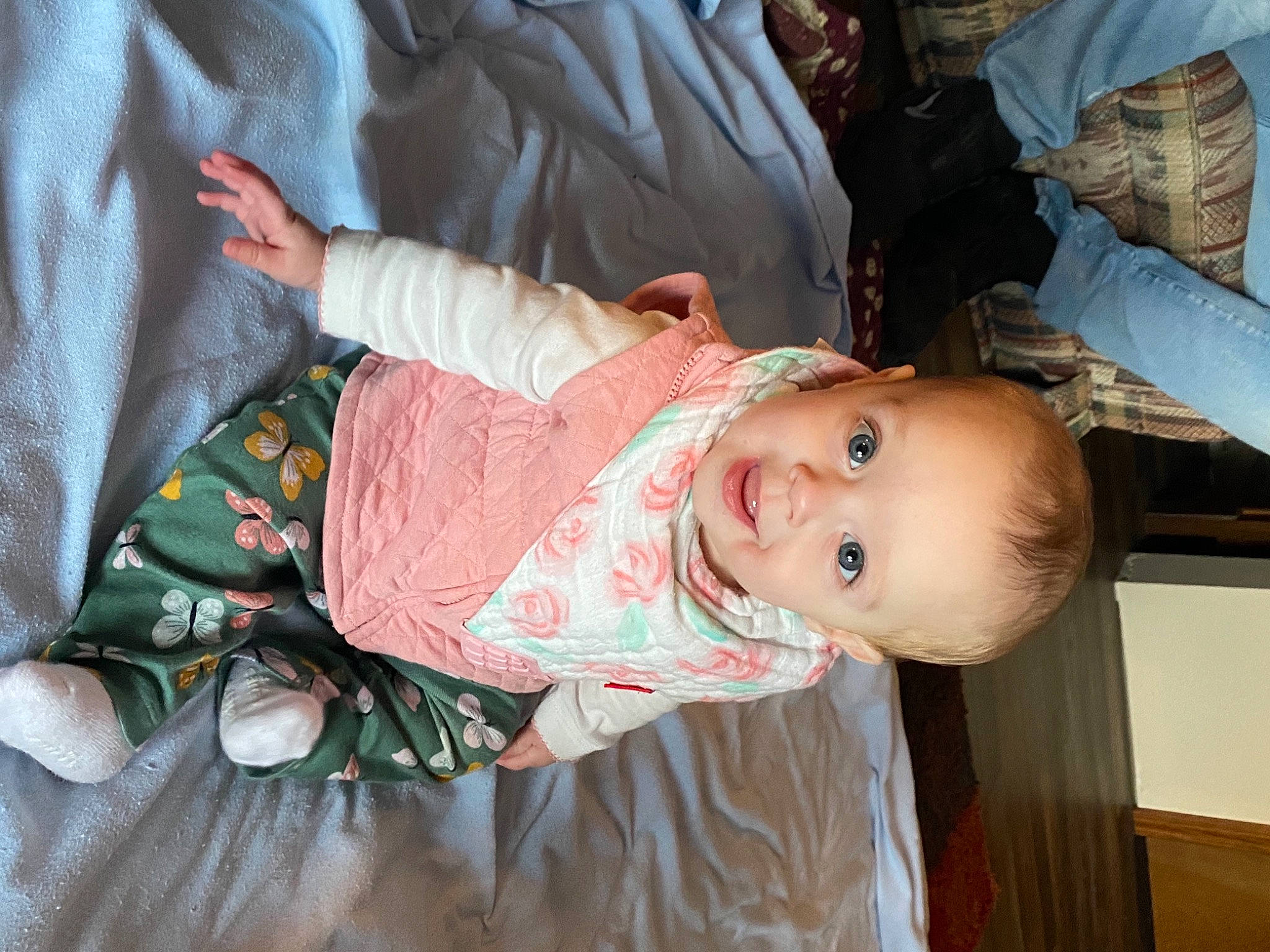 Brynlee is registered to the contest to win money with this photo: baby, baby_products, baby_toddler_clothing, cheek, child, comfort, hairstyle, iris, mouth, nose, pattern, person, room, sitting, skin, sleeve, smile, toddler, tree, wood