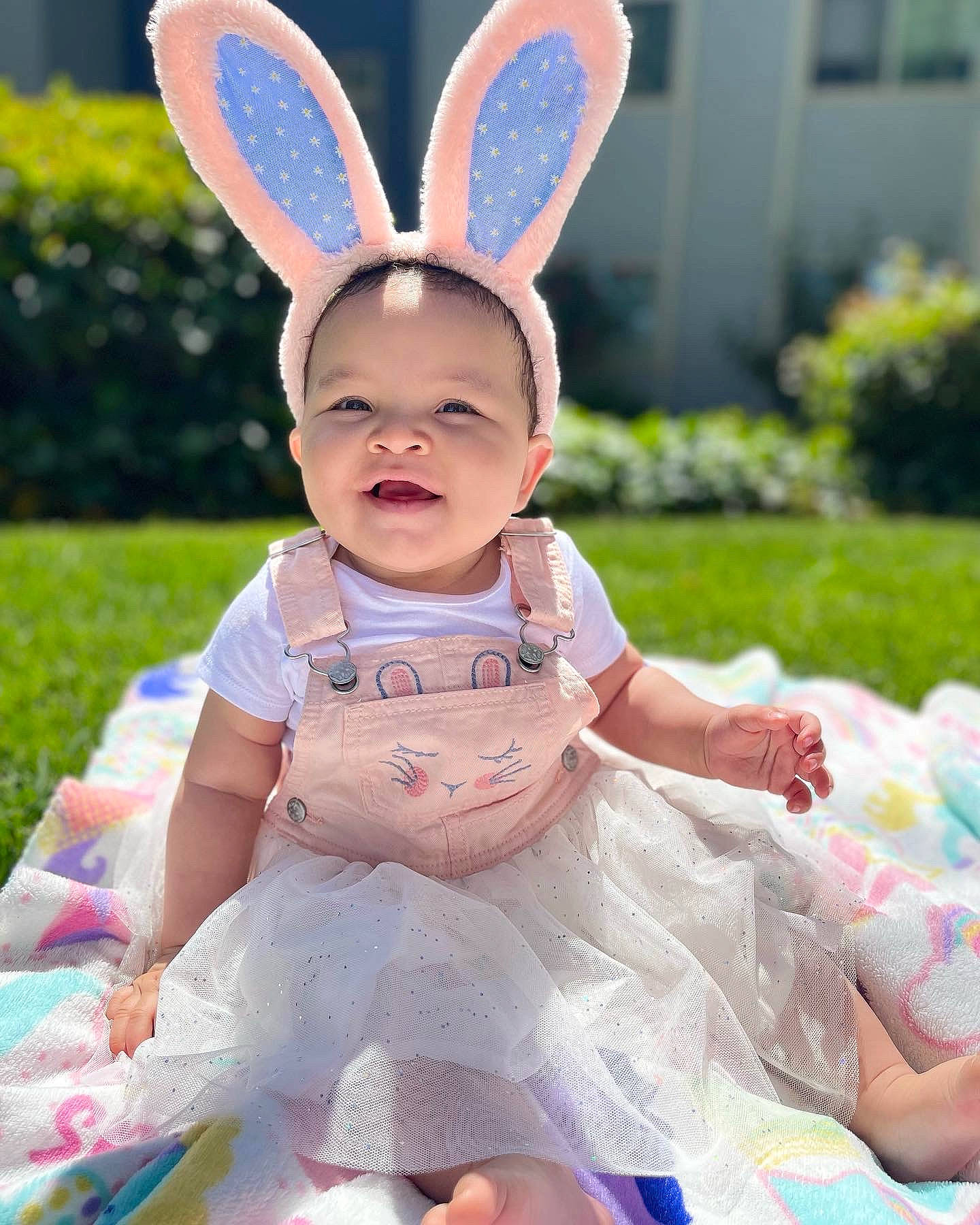 Kemai. is registered to the contest to win money with this photo: baby, baby_toddler_clothing, blue, child, costume_hat, easter, easter_bunny, event, face, fun, grass, happy, hat, person, pink, rabbit, sitting, skin, smile, toddler