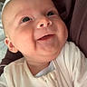 Benny is registered to the contest to win money with this photo: baby, infant, smile, face, onesie, child, portrait, closeup, happy, cute, skin, head, person, newborn, expression, indoors, young, human, warm, comfort