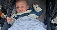 Benny joined the competition — help win amazing prizes! baby, infant, stroller, blanket, smile, face, child, cozy, clothing, cute, portrait, resting, comfort, baby_boy, head, hand, fabric, pattern, outdoor, soft