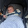 baby, infant, stroller, blanket, smile, face, child, cozy, clothing, cute, portrait, resting, comfort, baby_boy, head, hand, fabric, pattern, outdoor, soft